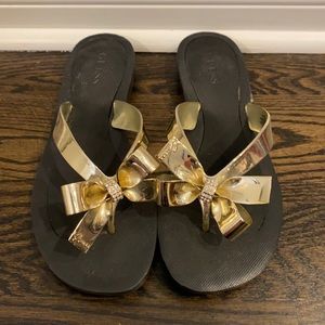 Black and gold bow gas flip-flops size 9